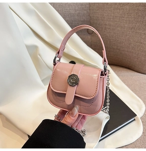 Detail of pink mini square bag with metallic C buckle on satin fabric backdrop
