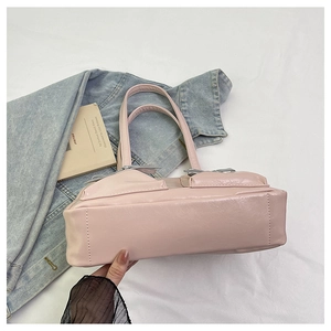 Detail of pink PU leather tote bag with bow accents and matte textured finish