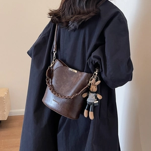 Vintage dark brown bucket bag with woven chain strap and cute bunny charm on model