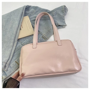 Close-up of light pink tote bag with dual slim handles and zipper on a clean fabric setup