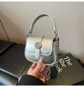 Detail of silver metallic mini bag with floral C buckle and chain strap for crossbody wear