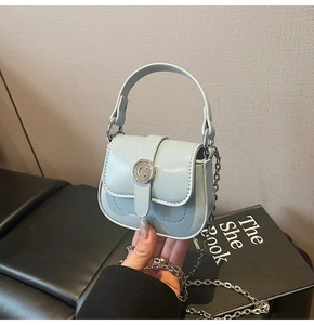 Detail of light blue mini square bag with silver metal C buckle and chain strap
