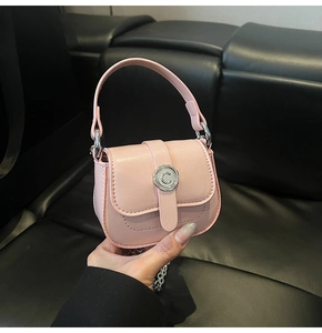 Detail of pink mini bag with textured leather, silver C buckle and metallic chain strap