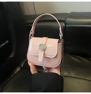 Detail of pink glossy mini bag with silver metal C-buckle and elegant chain strap