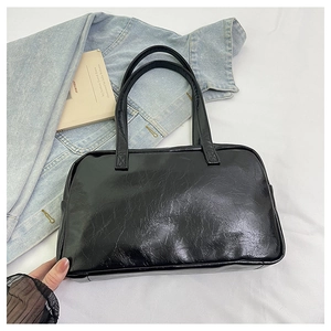 Detail of black glossy tote bag with vintage oil-wax texture and double top handles
