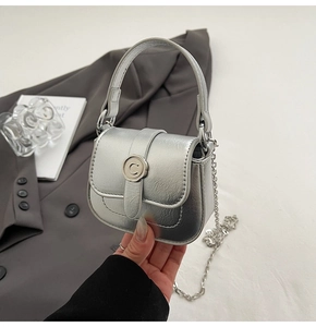 Detail of silver mini square bag with metallic buckle and elegant chain strap