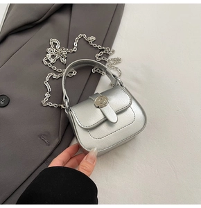 Detail of silver mini square bag with metallic texture, chain strap, and round buckle