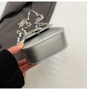 Macro side view of silver mini square bag with metallic finish and metal chain strap