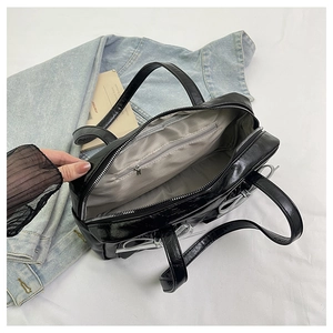 Interior view of black bow tote bag showing zipper compartments and gray fabric lining