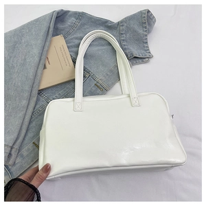 Detail shot of a white PU leather tote bag featuring sleek straps and a minimalist design