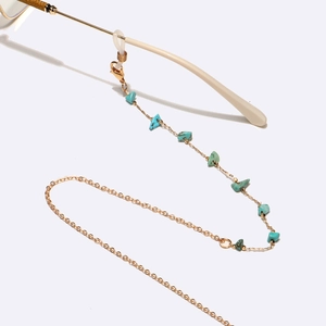 Detail of gold chain eyewear strap with turquoise stones and silicone connector
