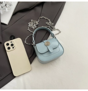 Detail of light blue mini square bag with silver C-buckle and fine leather texture