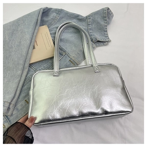 Detailed view of silver metallic tote bag with pleated texture and stylish top handles