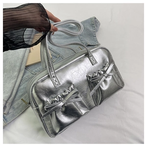 Close-up of silver bow-knot tote bag with metallic crinkled leather and ruffled pockets