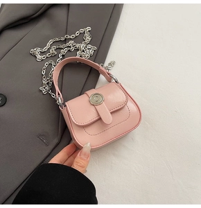 Detail view of pink mini square bag featuring silver floral clasp and metal chain strap