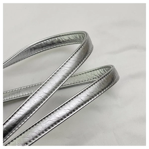 Close-up of silver metallic leather strap with detailed double stitching and crinkled texture