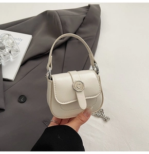 Close-up of beige PU leather mini bag with silver metal buckle and chain strap detail