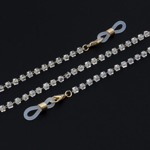 Detail of golden eyeglass chain with clear crystal cubes and non-slip rubber loops