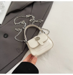 Detail of mini cream square bag with silver chain strap and C-pattern buckle