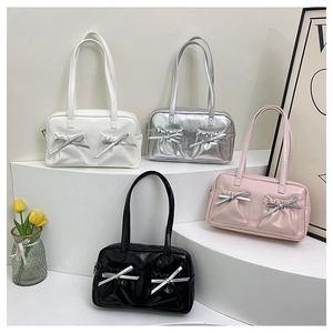 Detail of four solid color shoulder bags with front pockets and silver bow decorations
