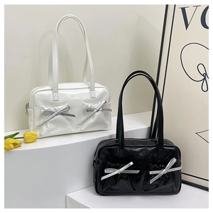 Detailed view of glossy patent leather tote bags with elegant silver ribbon bow accents