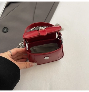 Interior view of the mini red square bag showing grey fabric lining and magnetic closure