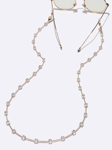 Detailed view of golden metal eyeglass chain with square crystals and non-slip loops