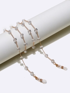 Detail of gold eyewear chain with clear square crystal beads and silicone non-slip loops