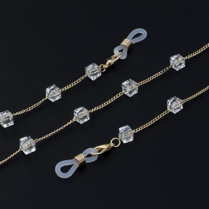 Gold glasses chain with square crystals and adjustable silicone loops on black background