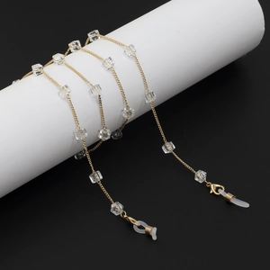Detail of gold eyewear chain with transparent square crystals and silicone loops