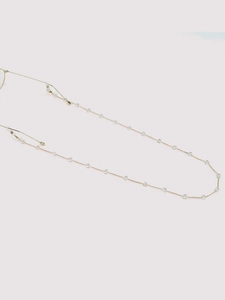 Close-up of golden eyewear chain featuring clear square crystal beads and silicone loops
