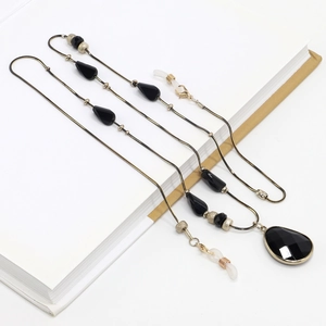 Gold snake chain eyewear strap featuring black teardrop crystals and metallic beads