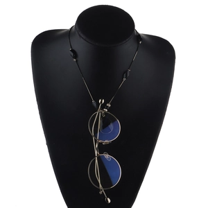Detail of golden round metal glasses with a black beaded snake chain on a neck display