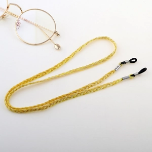 Bright yellow woven eyeglass strap with adjustable silicone loops on a white background