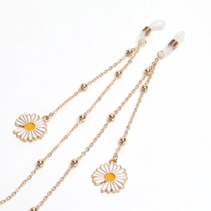 Golden metal glasses chain featuring white daisy charms and small gold beads on white background