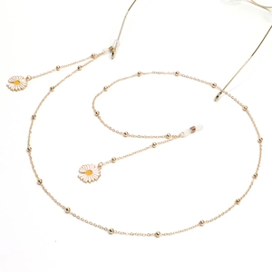 Golden eyewear chain with white daisy pendants and small beads on white background