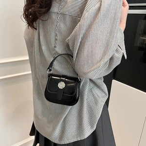Black glossy mini crossbody bag with silver buckle and metal chain strap for women