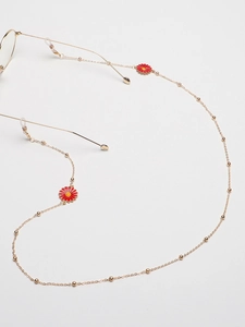Detail of golden metal eyewear chain with red daisy charms and silicone non-slip loops