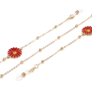 Golden metal glasses chain with daisy charms and beads on white background