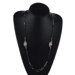 Sautoir long en métal argenté et cordon noir avec pendentifs perles sur mannequin