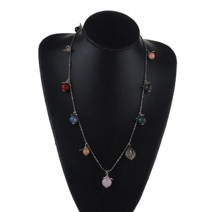 Colorful bohemian sweater chain with gold leaves and multi-colored beads on black bust