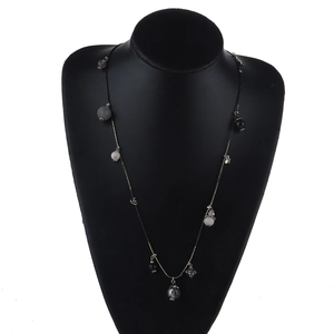 Long collier bohème en perles avec perles noires et pendentifs étoiles dorées sur mannequin