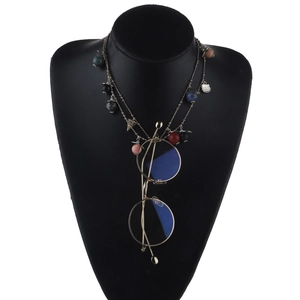 Detail of gold glasses holder necklace with multi-color beads and round metal pendant