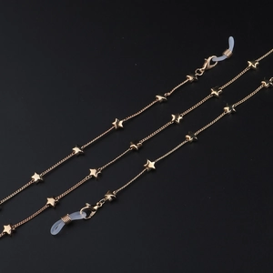 Catenella per occhiali dorata con stelle metalliche e passanti in silicone su fondo nero