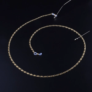 Golden metal eyeglass chain with twisted link design and rubber loops on black background