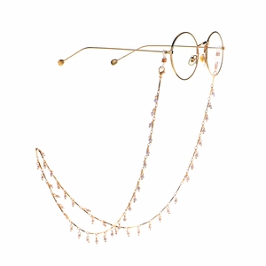 Fashionable golden metal eyewear chain with white pearls and round glasses on white background