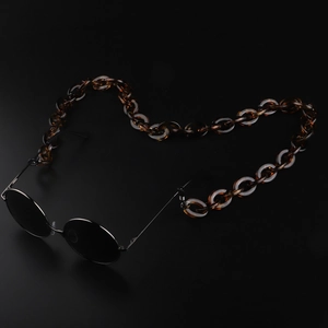 Retro round sunglasses with thick amber tortoiseshell acrylic chain on black background