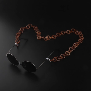 Chaîne de lunettes en acrylique ambré disposée en forme de cœur sur fond noir
