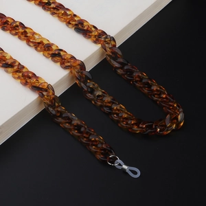 Detailed macro view of retro amber tortoiseshell acrylic chunky Cuban link eyewear chain