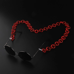 Détail macro d'une chaîne à lunettes rouge en acrylique en forme de cœur sur fond noir